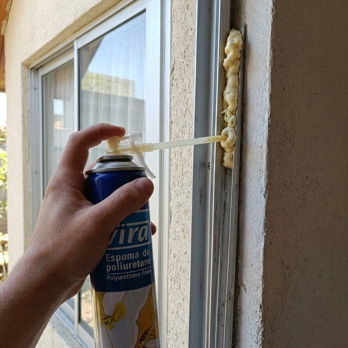 Espuma expansiva VIRA rellenando el hueco entre el marco de una ventana y el muro